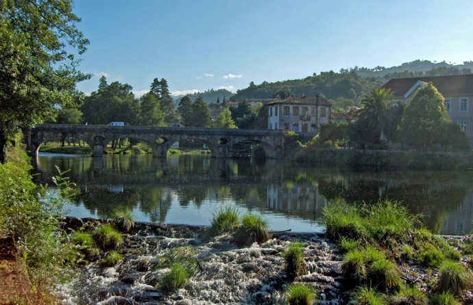 Ponte Velha de Arcos de Valdevez, onde passa o rio Vez, num dia assolarado, no lado direito há árvores verdes.