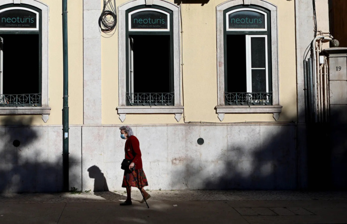 Idosa ao fundo a atravessar a rua