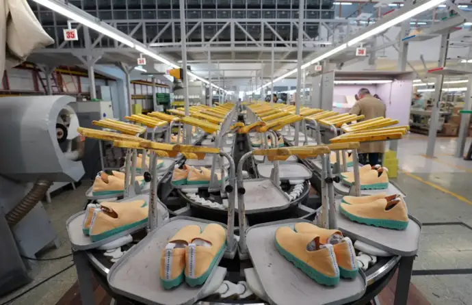 Fábrica de calçado com maquinaria no fundo