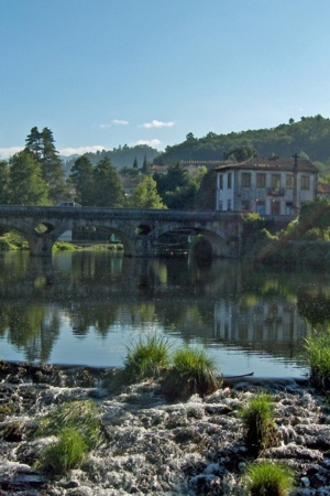 Ponte Velha de Arcos de Valdevez, onde passa o rio Vez, num dia assolarado, no lado direito há árvores verdes.