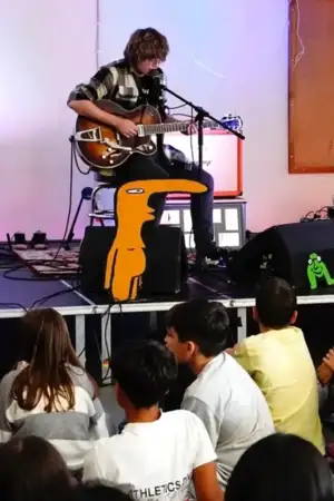 Um guitarrista num espetáculo, com uma luz vermelha sobre ele.