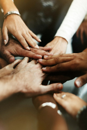 Várias mãos sobrepostas com o intuito de manifestarem solidariedade