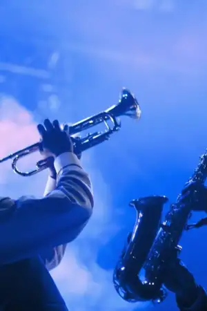 Duas pessoas num concerto de jazz, uma a tocar trompete e outra saxófone.