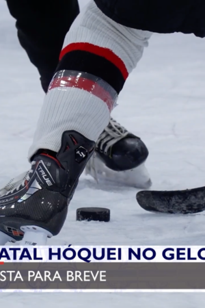 Pista de hóquei no gelo, com plano aproximado de uma disputa pelo disco por dois jogadores