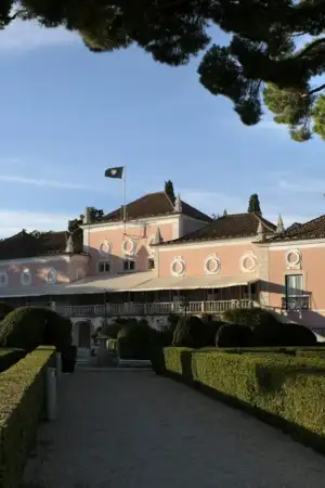 Jardim so Palácio de Belém, com o Palácio ao fundo iluminado por sol de fim de tarde