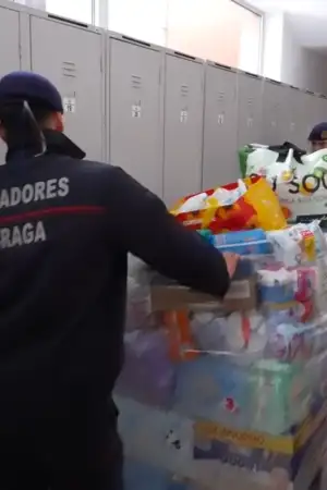 Um bombeiro empurra uma palete cheia de bens essenciais pelo corredor.