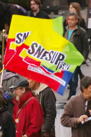 Imagem de uma manifestação, com cerca de dez pessoas, em que estão duas bandeiras do sindicato do Ensino Superior.