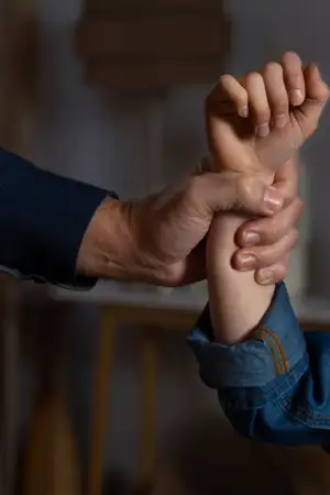 Imagem de pessoa a agarrar o braço de outra pessoa