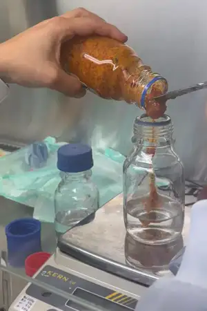 Medronho está dentro de um frasco num laboratório a ser manuseado por alguém com uma bata vestida