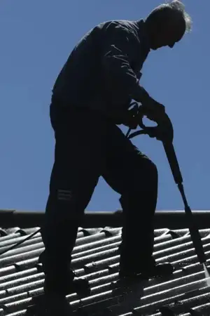 Homem a lavar telhado com pressão de água