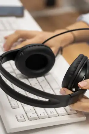 Mulher segura auscultadores em call center. Por baixo vê-se um teclado de um computador