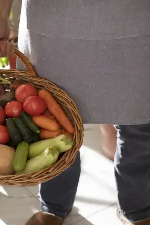 Homem a segurar cesta com legumes