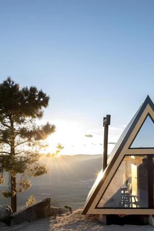 Uma casa triangular construída no topo da montanha ao nascer do sol