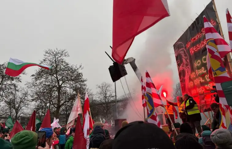 Manifestantes nas ruas de Estrasburgo, com cartazes, bandeiras e tochas.