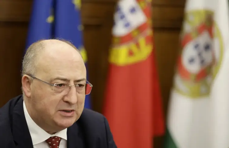 O ministro da agricultura, José Manuel Fernandes, com a bandeira da Europa e de Portugal atrás.