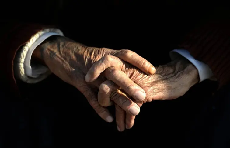 Mãos entrelaçadas de um senhor mais velho