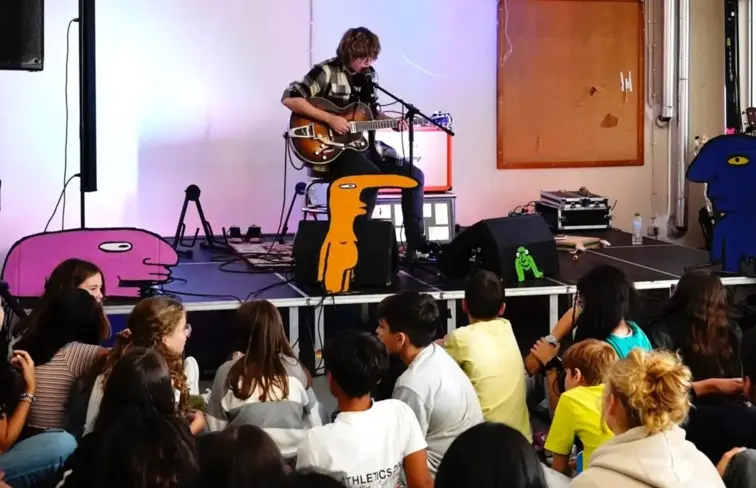 Um guitarrista num espetáculo, com uma luz vermelha sobre ele.