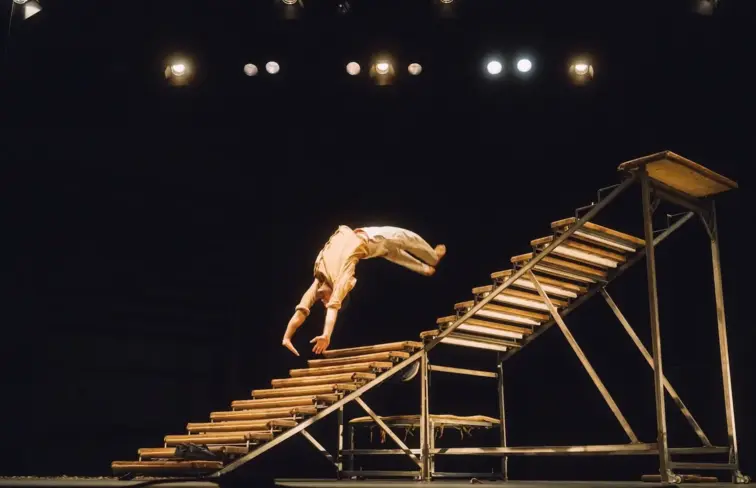 Espetáculo "Ákri", com um acrobata e uma escada.