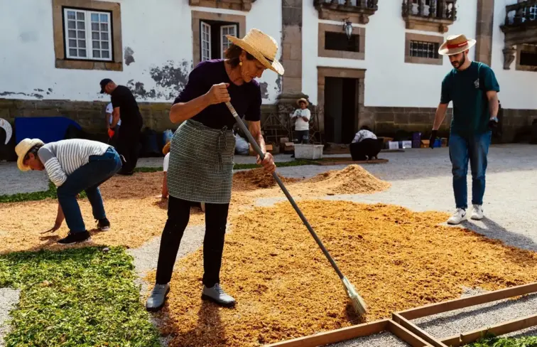 Pessoas a montarem o tapete na rua.