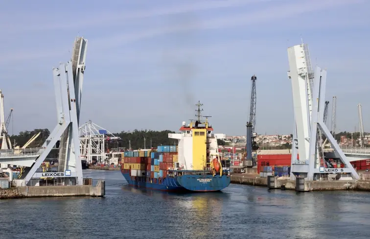 Porto de Leixões, com um barco com contentores a passar no meio de uma ponte móvel.