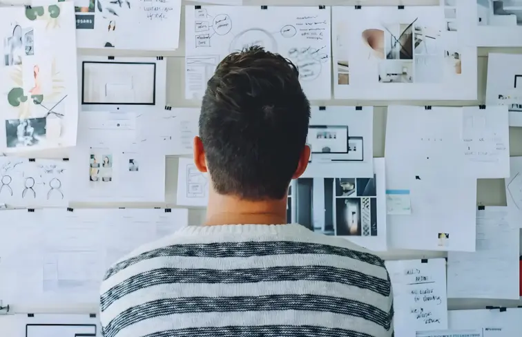 Estudante avalia anotações afixadas na parede