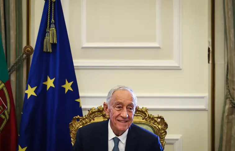 Presidente da República, Marcelo Rebelo de Sousa, sorri, com a bandeira da União Europeia atrás.