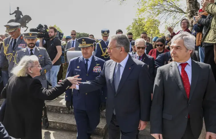 Seguro na cerimónia do Dia do Combatente dá a mão a senhora idosa.