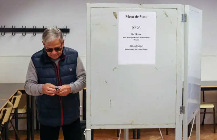 Um senhor idosos ao lado de uma secção de voto.