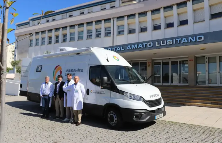 A nova Unidade Móvel de Saúde em frente ao hospital, com os profissionais de saúde ao lado.