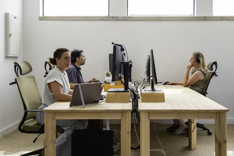 Três pessoas a trabalhar em frente ao computador