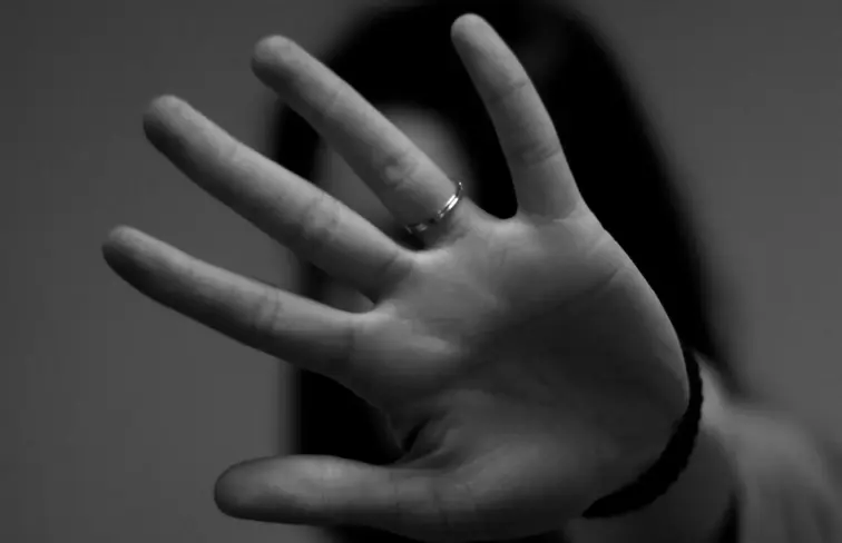 Mulher a esconder o rosto com a mão. Imagem Ilustrativa