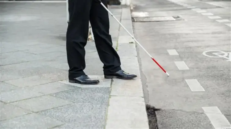 pessoa invisual a passar a passadeira