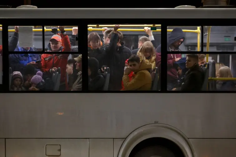 Autocarro a passar e o interior do veículo lotado de passageiros
