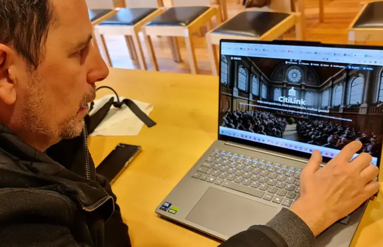 Homem olha para computador portátil com a página do citylink aberta