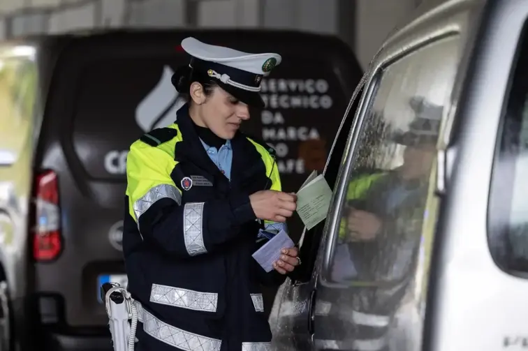 Na imagem, agente de autoridade em conversa com condutor.