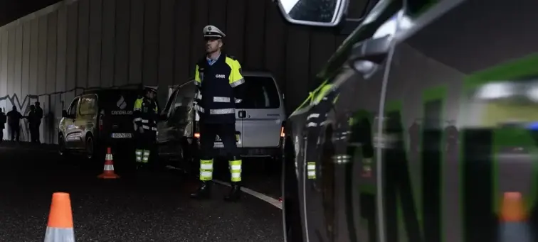 Agentes de autoridade em operação na estrada durante a noite.