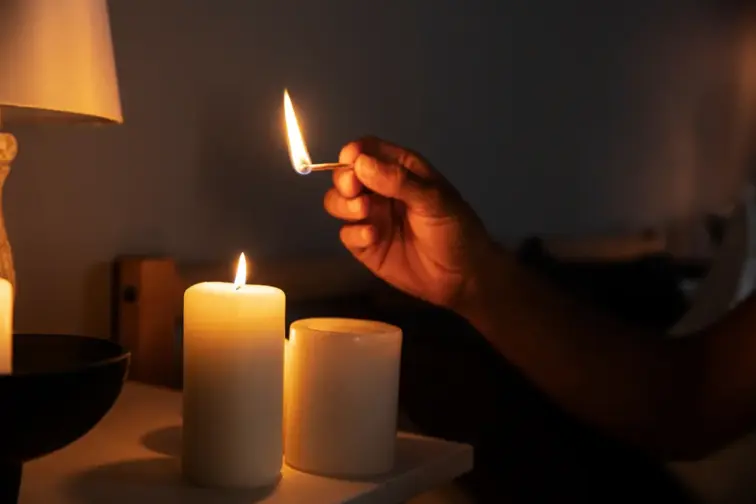 Uma pessoa a acender duas velas