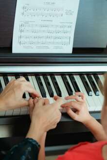 Aula de piano entre aluna e professora