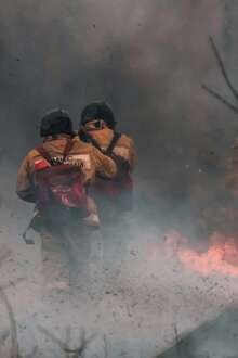 Bombeiros entre chamas.