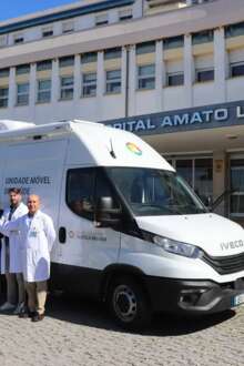A nova Unidade Móvel de Saúde em frente ao hospital, com os profissionais de saúde ao lado.