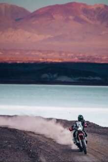 Um piloto a conduzir numa mota no deserto argentino