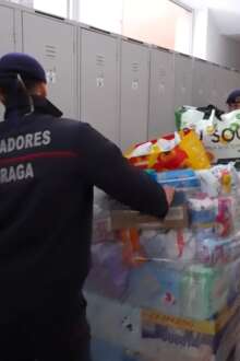 Um bombeiro empurra uma palete cheia de bens essenciais pelo corredor.