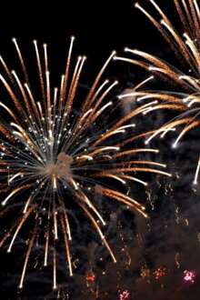 Fogos de artifício, no céu, à noite, da cor amarelo e laranja.