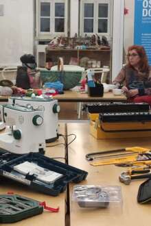 mulheres estão sentadas ao redor de uma mesa com ferramentas para obras e reparações