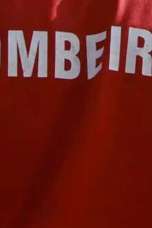 Na imagem, as costas de um bombeiro.